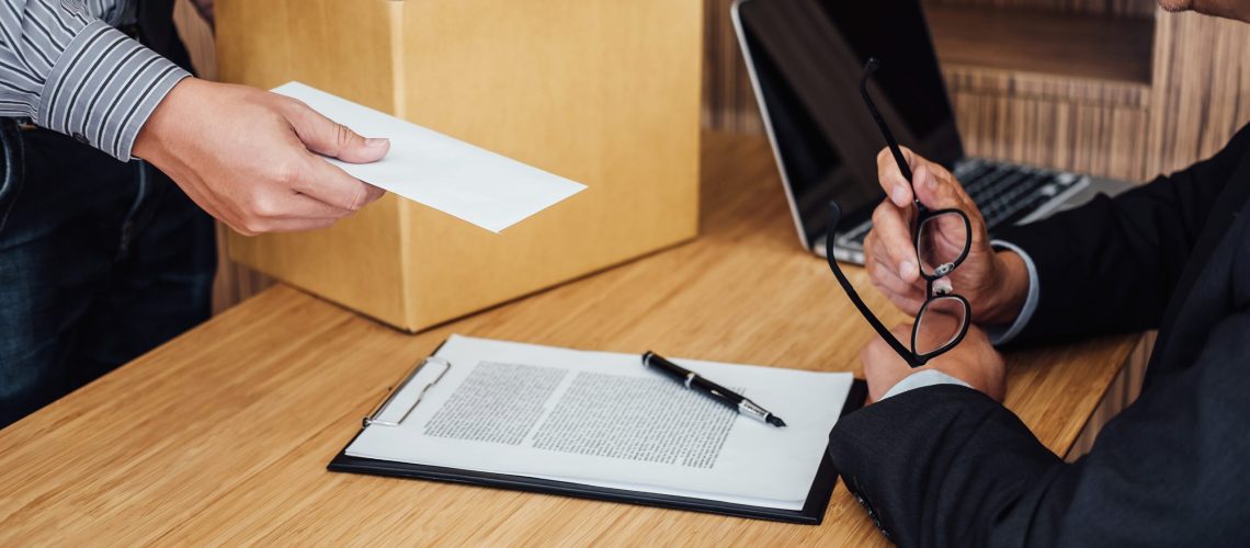 Aviso prévio indenizado: Empregado entregando carta de demissão para avisar o patrão enquanto carrega seus objetos pessoais